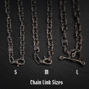 May include: Four silver-coloured chain necklaces with different link designs and clasps are displayed. The necklaces are labelled S, M, and L, with the text "Chain Link Sizes" below. The chains are shown against a dark background.