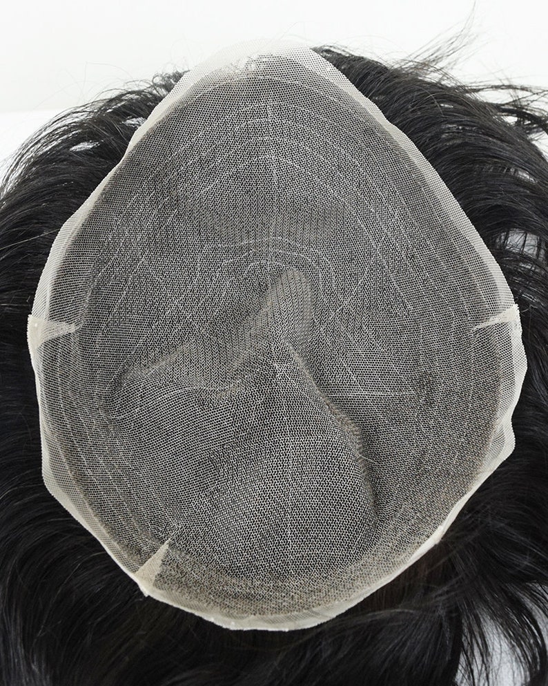Puede incluir: Primer plano de una peluca con base de malla. La peluca est&aacute; hecha de cabello humano negro y est&aacute; dise&ntilde;ada para cubrir una calvicie o el adelgazamiento del cabello.