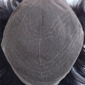 Puede incluir: Primer plano de una peluca con una base de malla negra y cabello humano negro. La peluca est&aacute; dise&ntilde;ada para ser fijada al cuero cabelludo para cubrir las zonas calvas o el cabello fino.