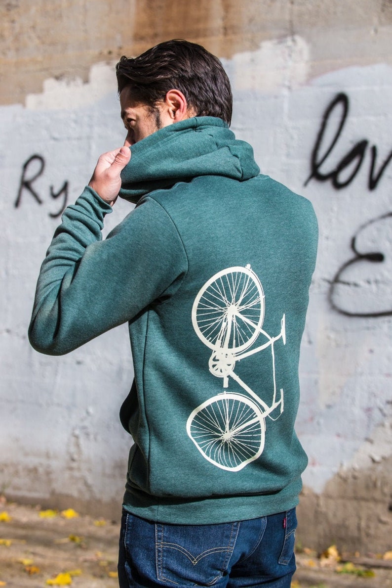 Op de afbeelding: Een tealgroen hoodie met een witte fietsafbeelding op de rug.