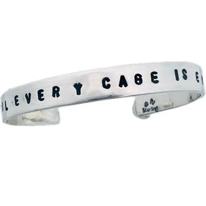 May include: A silver bracelet with the words "Be every you can be" engraved on it.