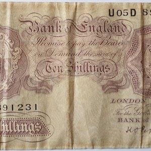 Puede incluir: Un billete antiguo de diez chelines del Banco de Inglaterra. El billete presenta texto e ilustraciones ornamentadas, incluido un retrato central y la denominación "10 chelines". El número de serie U05D 891231 es visible.