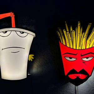 May include: Two cartoon character wall lights. One is a white milkshake with a red straw and yellow hands. The other is a red french fry container with yellow fries and a black mustache. Both have a grumpy expression.