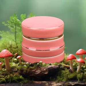 May include: A pink ceramic jar with gold trim. The jar has a cylindrical shape and is divided into three sections. The jar is sitting on a bed of moss and mushrooms.