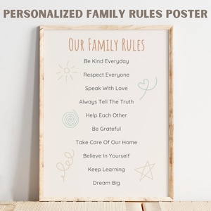 May include: A framed poster with the text "PERSONALIZED FAMILY RULES POSTER" at the top. The poster lists family rules such as "Be Kind Everyday" and "Dream Big" in a stylish font. Decorative elements include a sun, heart, and star.