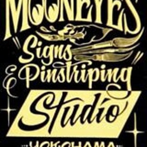 Könnte beinhalten: Schwarz-goldenes Logo für ein Zeichen- und Pin striping-Studio namens "Mooneyes" mit dem Text "Yokohama" und "Seit 1989" darunter.