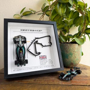 Puede incluir: Una impresión enmarcada del circuito de Silverstone con un coche de Fórmula 1 en miniatura delante. La impresión incluye la fecha de la carrera, el 7 de julio de 2024, y el nombre de la carrera, British GP. La impresión también incluye información sobre la carrera, como el primer gran premio, el número de vueltas, la longitud del circuito y el récord de vuelta.