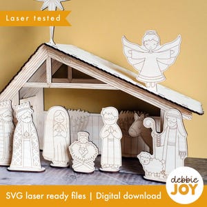 May include: A wooden nativity scene with laser-cut figures, including the Holy Family, wise men, an angel, and a sheep. The scene includes a stable with a star on top. The text "Laser tested" and "SVG laser ready files | Digital download" are visible.
