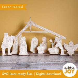 May include: A wooden nativity scene with figures of the Holy Family, wise men, an angel, and animals. The scene includes a star and a stable. The text "Laser tested" and "SVG laser ready files | Digital download" are visible.