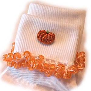 May include: White ankle socks with an orange glitter pumpkin applique and an orange beaded trim.