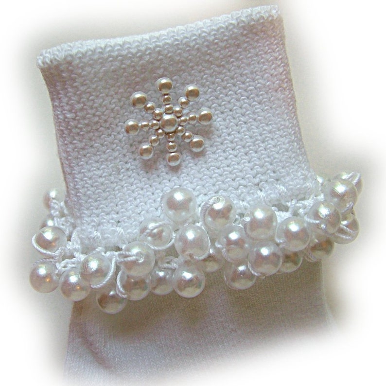 May include: White socks with a pearl trim and a silver snowflake embellishment.