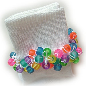 May include: White sock with a colorful beaded trim. The beads are various shades of blue, green, pink, yellow, and orange.