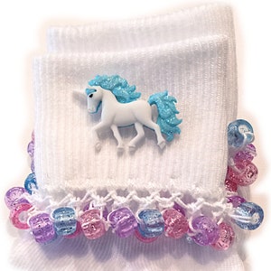 May include: White socks with a blue and white unicorn applique and a crocheted trim with colourful beads.
