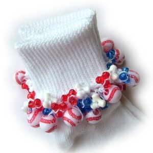 May include: White ankle socks with a red, white, and blue beaded trim. The beads are shaped like baseballs and have a white stitching design.