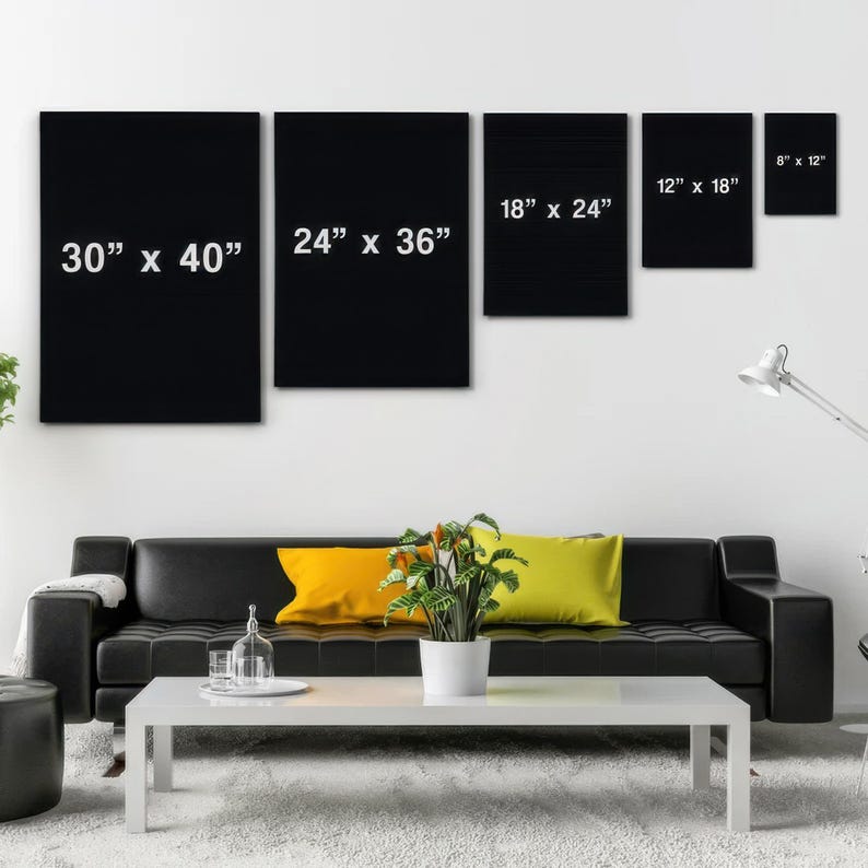 May include: Five black rectangular canvas prints of varying sizes are displayed on a white wall. The largest is 76cm x 102cm, followed by 61cm x 91cm, 46cm x 61cm, 30cm x 46cm, and 20cm x 30cm. A black leather sofa, white coffee table, and potted plant are in front.
