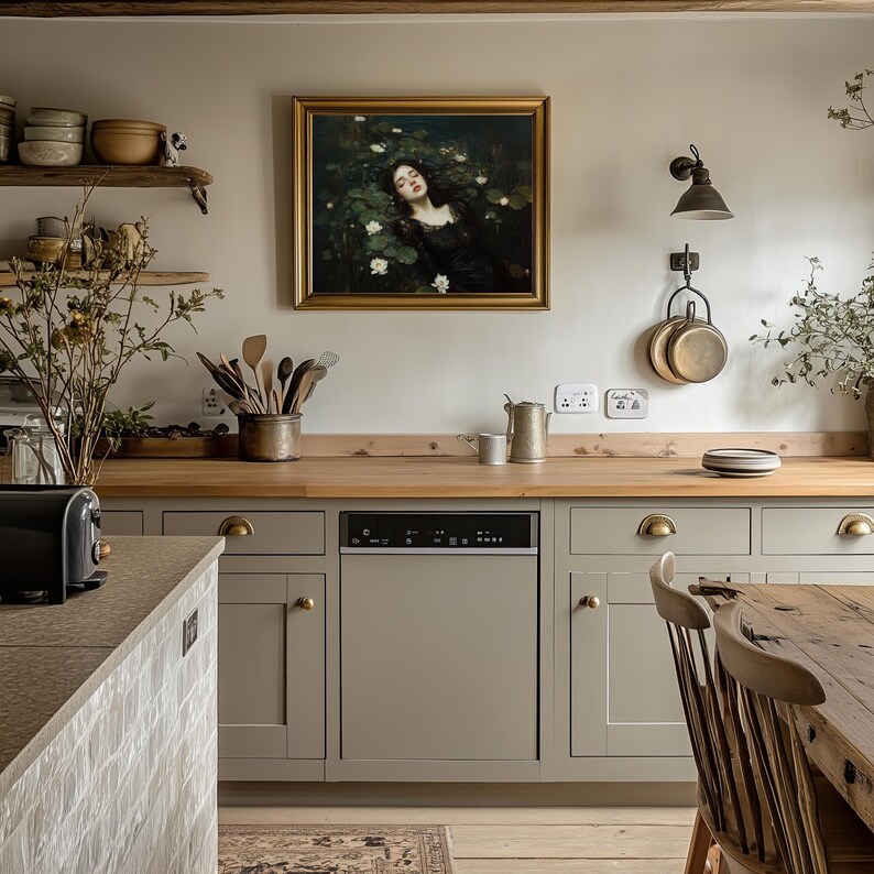 May include: A kitchen featuring light grey cabinets, wooden worktops, and a framed painting. The painting shows a woman surrounded by white flowers. Kitchen utensils and copper pans hang on the wall. A black dishwasher is integrated into the cabinetry.