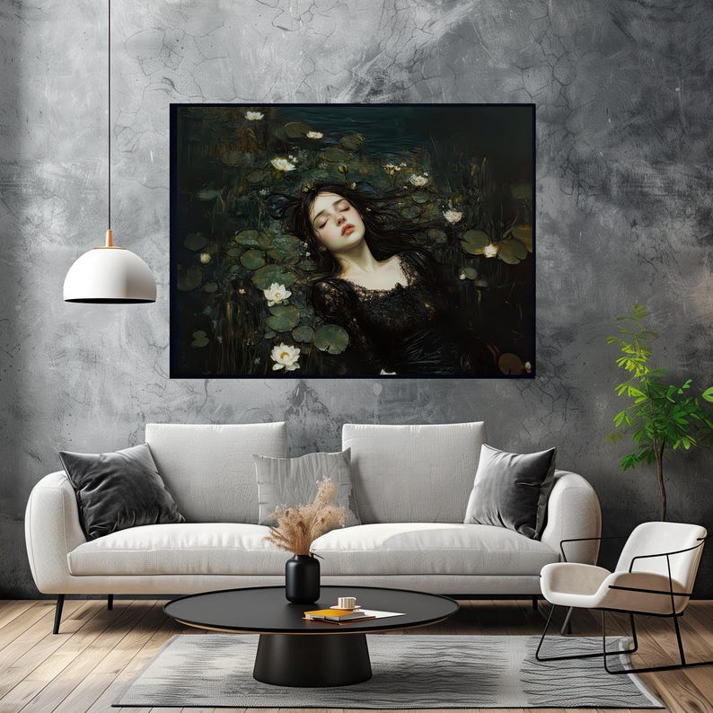 May include: A framed art print showing a woman in a black dress amongst lily pads and white flowers. The artwork has a dark, moody aesthetic, with a focus on the woman's face and the surrounding water. The print is displayed above a white sofa.