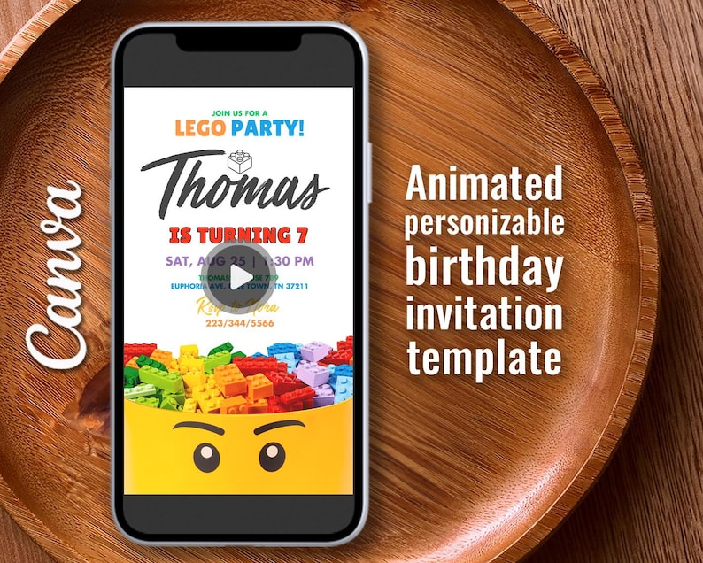 May include: A smartphone displays a birthday party invitation template. The invitation features the text "LEGO PARTY!" and "Thomas is turning 7." Colorful toy bricks are at the bottom, with a yellow face design. The background is a wooden tray.