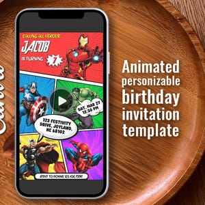 Puede incluir: Un teléfono inteligente muestra una plantilla de invitación de cumpleaños estilo cómic con superhéroes. La invitación incluye el texto "JACOB IS TURNING" y los detalles del evento. El teléfono está sobre una bandeja de madera.