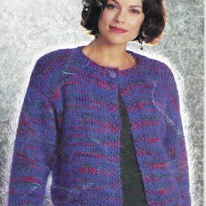 Peut inclure: Un cardigan rayé violet, rose et vert avec une fermeture à un seul bouton. Le cardigan est tricoté et a une coupe ample.