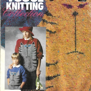 May include: A vintage Vogue Knitting International Collection magazine cover. The cover features a large knitted cat design in shades of yellow, orange, and black. The magazine also shows a woman and child wearing cat-themed sweaters. The text "FOR CAT LOVERS" is at the bottom.