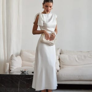 Vestido midi elegante de cetim com laço no ombro, vestido minimalista para recepção de noiva, roupa para convidada de casamento, vestido de cetim simples e discreto.