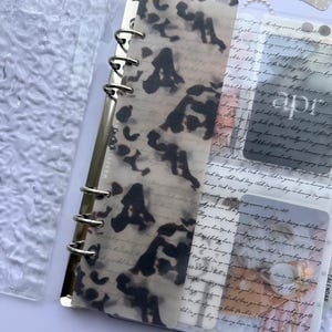 May include: A set of three ceramic mugs with a speckled, matte finish. The mugs are in shades of cream, light gray, and dark gray. Each mug has a simple, minimalist design and a rounded handle.