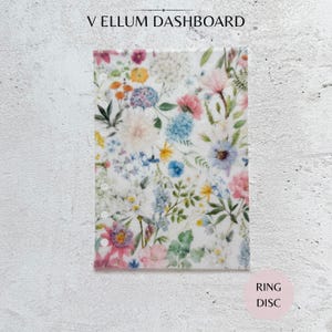 May include: A translucent vellum dashboard featuring a colourful botanical print of various wildflowers and garden blooms in shades of pink, blue, yellow, and green. The rectangular sheet has a vertical row of circular punch holes along the left side.