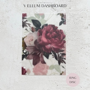 May include: A rectangular vellum dashboard featuring a floral print with deep burgundy, dark pink, and light pink roses and lilies. The translucent sheet has six circular punch holes along the left edge for binder insertion and the text V ELLUM DASHBOARD.