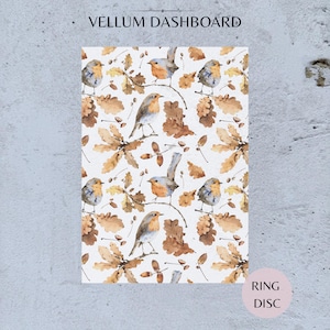 May include: A vellum dashboard featuring a repeating pattern of small orange-breasted birds perched on branches surrounded by brown oak leaves and acorns. The text VELLUM DASHBOARD is printed at the top, and RING DISC is printed in a circle at the bottom.