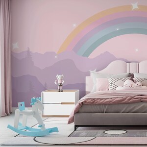Pu&ograve; includere: Una cameretta con un murale arcobaleno pastello, un cavallo a dondolo bianco e blu e un letto con biancheria da letto rosa. Un piccolo comodino bianco contiene una statuina. La stanza ha un'atmosfera morbida e accogliente.