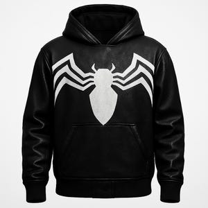 May include: Black hooded sweatshirt with a white Venom graphic on the front. The sweatshirt has a kangaroo pocket and a leather-like texture. The graphic is a stylized spider-like design.