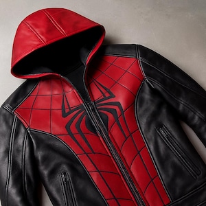 May include: Black and red hooded jacket with a full-length zip. The jacket features a red spiderweb design on the chest and hood, with a large black spider emblem. The sleeves and back are black.