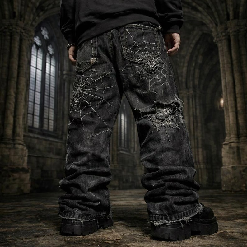 Pode incluir: Jeans pretos com bordado de teia de aranha branca e detalhes desgastados. Os jeans t&ecirc;m um corte folgado e s&atilde;o combinados com botas de plataforma pretas. O fundo mostra um interior g&oacute;tico com janelas arqueadas.