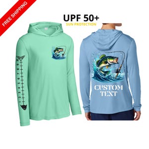 May include: A light green long-sleeve hooded shirt with a fish graphic on the chest and a fish ruler on the sleeve. A light blue long-sleeve hooded shirt with a large fish graphic on the back, the text CUSTOM TEXT, and UPF 50+ sun protection.