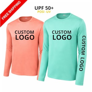 May include: Two long-sleeve crew neck shirts, one in coral and one in mint green, both featuring the text CUSTOM LOGO printed in black on the chest. The mint green shirt also displays the text CUSTOM LOGO vertically along the left sleeve.