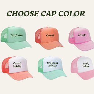 May include: Six trucker hats in various colors: seafoam, coral, and pink. Each hat has a mesh back and a solid front panel. The text "CHOOSE CAP COLOR" is at the top. The hats are labeled with their color names, including "Seafoam, White".