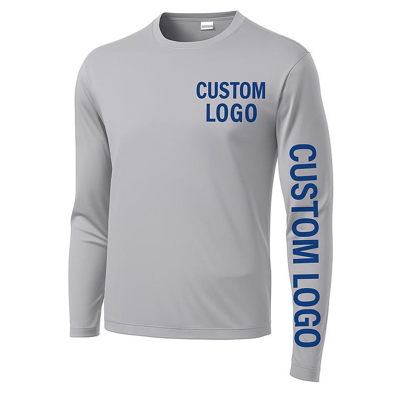 以下が含まれることがあります： 胸と右袖に青色の「CUSTOM LOGO」の文字がプリントされた、ライトグレーの長袖シャツ。 シャツはクルーネックで、滑らかな、おそらく運動用の素材で作られています。