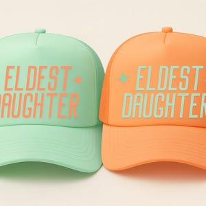 Printed eldest daughter trucker hat with mesh back, designed as a casual keepsake gift for daughters, perfect for birthdays or family matching outfits.