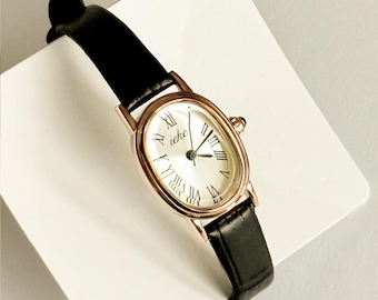 Reloj vintage de oro rosa para mujer: esfera ovalada, correa de piel negra