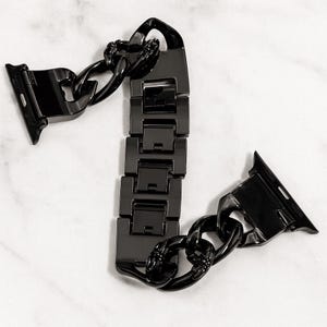 以下が含まれることがあります： 黒色のチェーンリンクデザインの時計バンド。 バンドは金属製で、光沢のある仕上げです。 スマートウォッチに合うように設計されており、クラスプクロージャーが付いています。