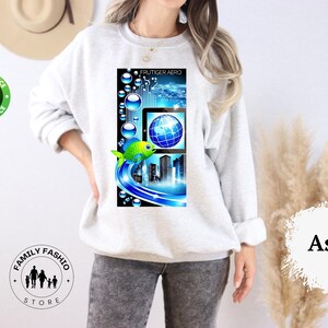 May include: Light gray sweatshirt with a colorful graphic. The graphic features a digital design with a globe, cityscape, and a green fish. The text "FRUTIGER AERO" is at the top of the graphic.