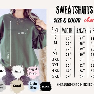 May include: An olive green sweatshirt with a size and color chart. The chart lists measurements in inches for width, length, and sleeve length, ranging from size small to 5XL. Color options include white, ash, light pink, sport grey, sand, light blue, and black.