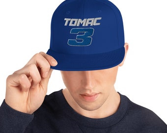 May include: A royal blue baseball cap with a white and silver embroidered logo that says "TOMAC 3".