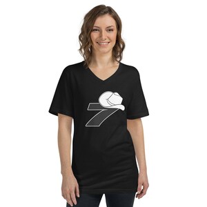 May include: A black v-neck t-shirt with a white graphic of the number 7 with a cowboy hat on top.
