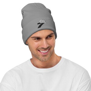 May include: A gray beanie with a black and white embroidered number seven on the front.