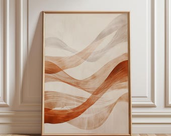 May include: Abstract art print featuring flowing, layered ribbons in shades of terracotta, beige, and gray. The artwork is framed in a light wood frame and leans against a white wall and wooden floor.