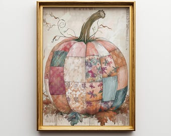 May include: A framed print featuring a patchwork pumpkin in shades of pink, orange, and teal. The pumpkin is composed of various fabric patterns and sits atop autumn leaves. The frame is gold.