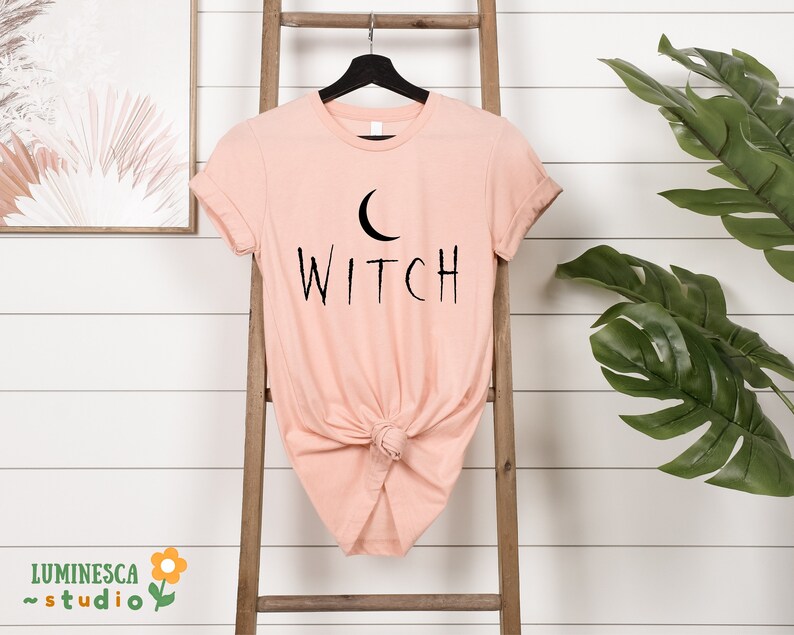 a t - shirt that says witch hanging on a ladder