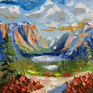 May include: Square oil painting of a mountain landscape with a lake. The artwork features textured brushstrokes in shades of blue, orange, green, and white. The sky is a light blue with white clouds, and the foreground shows a path and red flowers.